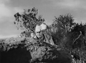 Blazing the Overland Trail--Roberts behind rock